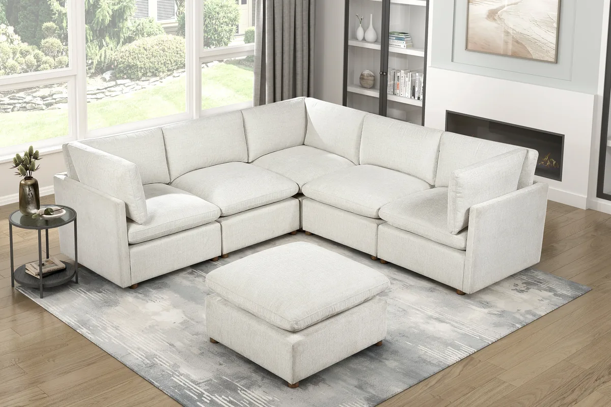Cream sectional sofa and matching ottoman beside living room windows